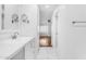 Bright white bathroom features tiled floor, vanity with marble countertop and large mirror at 4200 N Miller Rd # 112, Scottsdale, AZ 85251