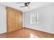 Cozy bedroom features wood floors, ceiling fan, and natural light from the window at 4200 N Miller Rd # 112, Scottsdale, AZ 85251
