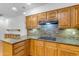 Kitchen with wood cabinets, mosaic backsplash, and electric cooktop at 4200 N Miller Rd # 112, Scottsdale, AZ 85251