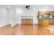 Living room with wood floors, base cabinets, and adjacent kitchen with granite counters at 4200 N Miller Rd # 112, Scottsdale, AZ 85251