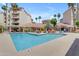 Large community pool perfect for swimming laps or relaxing poolside with lounge chairs and lush greenery at 4200 N Miller Rd # 112, Scottsdale, AZ 85251