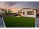 Home's backyard with artificial grass, adjacent patio, and a built-in outdoor grill at 4352 N 91St Gln, Phoenix, AZ 85037