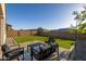An outdoor seating area on a paved patio adjacent to the artificial grass yard at 4352 N 91St Gln, Phoenix, AZ 85037