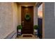 Charming front entrance with a dark wood door, seasonal wreath, and decorative potted plants for a welcoming touch at 4352 N 91St Gln, Phoenix, AZ 85037