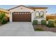 Inviting front exterior featuring a tile roof, arched windows, two-car garage, and landscaped yard at 4352 N 91St Gln, Phoenix, AZ 85037