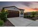 Welcoming home exterior featuring a tile roof, spacious two-car garage, and carefully landscaped front yard at 4352 N 91St Gln, Phoenix, AZ 85037