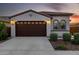 Inviting front exterior featuring a tile roof, arched windows, two-car garage, and beautifully landscaped yard at 4352 N 91St Gln, Phoenix, AZ 85037