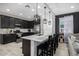 Kitchen with dark cabinetry, stainless steel appliances, and a breakfast bar with stylish pendant lighting at 4352 N 91St Gln, Phoenix, AZ 85037