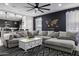 Bright living room featuring a gray sectional sofa, decorative coffee table, black and white rug, and accent wall at 4352 N 91St Gln, Phoenix, AZ 85037