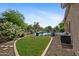 Landscaped backyard with a swimming pool, lush trees, and a small patch of grass at 4466 S Brice --, Mesa, AZ 85212