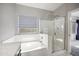 Bright bathroom featuring separate tub and shower with tile surround and glass door at 4466 S Brice --, Mesa, AZ 85212
