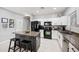Bright kitchen with granite countertops, white cabinets, black appliances, and a functional island with bar stools at 4466 S Brice --, Mesa, AZ 85212