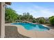 Sparkling pool in landscaped backyard, surrounded by lush greenery and a rock waterfall at 4466 S Brice --, Mesa, AZ 85212