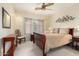 Bright bedroom featuring neutral walls, a ceiling fan, and a wooden sleigh bed with decorative wall art at 4738 N Greenview W Cir, Litchfield Park, AZ 85340