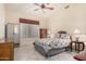 Bedroom with tile floors, a ceiling fan, and ample storage space in the closet and dresser at 4738 N Greenview W Cir, Litchfield Park, AZ 85340