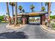 Elegant community entrance with a charming guardhouse, mature palm trees, and manicured landscaping, showcasing a welcoming environment at 4738 N Greenview W Cir, Litchfield Park, AZ 85340
