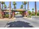 A gated community entrance featuring brick columns, palm trees, and manicured landscaping that provides secure access at 4738 N Greenview W Cir, Litchfield Park, AZ 85340