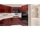Well-equipped kitchen with gas range, oven, microwave, tile flooring, and dark wood cabinets at 4738 N Greenview W Cir, Litchfield Park, AZ 85340