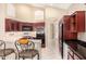 This kitchen features an eat-in breakfast bar with tile floors, dark wood cabinets, and stainless appliances at 4738 N Greenview W Cir, Litchfield Park, AZ 85340