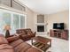 Comfortable living room features tile flooring, a fireplace, and abundant natural light from large window at 4738 N Greenview W Cir, Litchfield Park, AZ 85340