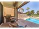 Relaxing covered patio with a built-in grill and comfortable seating, overlooking the sparkling pool and green landscape at 4738 N Greenview W Cir, Litchfield Park, AZ 85340