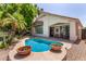 Private backyard pool with tranquil waterfall features, mature landscaping, and a shaded patio, ideal for outdoor entertaining at 4738 N Greenview W Cir, Litchfield Park, AZ 85340