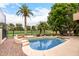 Backyard showcasing a pool with a spa, set against a backdrop of palm trees and manicured greenery at 4738 N Greenview W Cir, Litchfield Park, AZ 85340