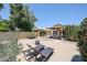 Large backyard with a covered patio, fire pit, and desert landscaping, providing a serene outdoor experience at 4765 E Charleston Ave, Phoenix, AZ 85032