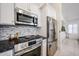 Updated kitchen features stainless steel appliances, granite countertops, and a mosaic backsplash at 4765 E Charleston Ave, Phoenix, AZ 85032