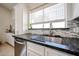 Modern kitchen featuring a stainless steel sink, granite countertops, and mosaic tile backsplash at 4765 E Charleston Ave, Phoenix, AZ 85032