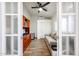 View through French doors of office with built-in desk, shelving, sofa, and closet storage at 4765 E Charleston Ave, Phoenix, AZ 85032