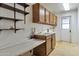 A utility room with ample storage cabinets, open shelves, sink, and countertop space is perfect for laundry tasks at 504 N Emerson --, Mesa, AZ 85201
