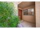 Inviting entrance features a brown door and ample natural light through the window, surrounded by lush green shrubbery at 5122 E Shea Blvd # 1043, Scottsdale, AZ 85254