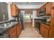 Well-equipped kitchen with stainless steel appliances, granite countertops, wood floors, and view into living area at 5122 E Shea Blvd # 1043, Scottsdale, AZ 85254