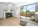 Bright living room with modern fireplace, wood floors, light-colored sofa, and sliding doors to the patio at 5122 E Shea Blvd # 1043, Scottsdale, AZ 85254