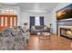 Bright living room showcasing a cozy fireplace, comfortable sofas, laminate wood floors and ample natural light at 5322 W Wethersfield Dr, Glendale, AZ 85304