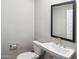 Bathroom features a pedestal sink, framed mirror, and a toilet at 5859 E Covey Ln, Phoenix, AZ 85054