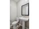 Bathroom features a pedestal sink, framed mirror, and a toilet at 5859 E Covey Ln, Phoenix, AZ 85054