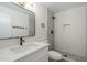 Modern bathroom with white vanity, dark fixtures, and a walk-in shower with gray tiling at 6601 N 46Th Ln, Glendale, AZ 85301