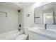 Updated bathroom featuring a bathtub with white tiling and a white vanity with black hardware at 6601 N 46Th Ln, Glendale, AZ 85301