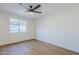 A bright and neutral bedroom featuring a ceiling fan, wood-look flooring and large windows at 6601 N 46Th Ln, Glendale, AZ 85301