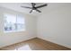 Sunlit bedroom with a large window, wood-look floors, and neutral walls at 6601 N 46Th Ln, Glendale, AZ 85301