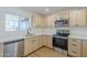 Bright kitchen featuring stainless steel appliances, light wood cabinets and white countertops at 6601 N 46Th Ln, Glendale, AZ 85301
