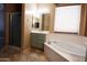 Well-lit bathroom featuring a soaking tub, separate shower, vanity with ample storage, and a tile floor at 6619 W Cordia Ln, Phoenix, AZ 85083