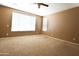 Empty bedroom featuring neutral-colored walls, carpet flooring, and two bright windows for ample natural light at 6619 W Cordia Ln, Phoenix, AZ 85083