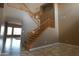 Bright foyer featuring a staircase with wood banisters, neutral walls, and tile flooring at 6619 W Cordia Ln, Phoenix, AZ 85083