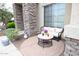 Cozy front patio with a charming wicker sofa and decorative round table, perfect for outdoor relaxation at 6619 W Cordia Ln, Phoenix, AZ 85083