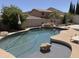 Backyard pool with a rock waterfall feature and desert landscaping, perfect for outdoor relaxation and entertaining at 6619 W Cordia Ln, Phoenix, AZ 85083