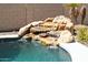 Close up of the backyard pool rock waterfall feature at 6619 W Cordia Ln, Phoenix, AZ 85083