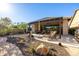 Beautifully landscaped backyard with covered patio and desert-friendly plants under a clear sky at 6929 E Quill St, Mesa, AZ 85207